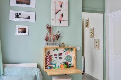 Cette chambre dispose d'une table avec une photo sur le mur. dans l'établissement Cosy studio proche du Canal Saint-Martin, à Paris