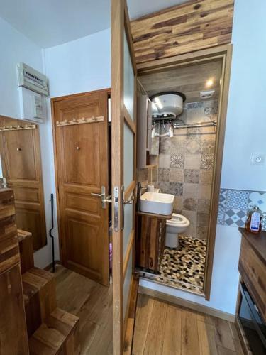 une salle de bain avec toilettes et porte en bois dans l'établissement Studio fonctionnel neuf, à Paris