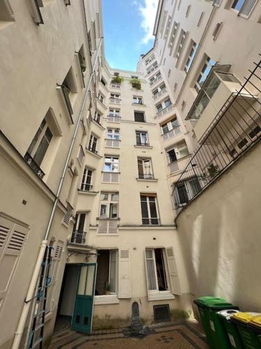 d'un grand immeuble blanc avec une porte verte. dans l'établissement Studio fonctionnel neuf, à Paris