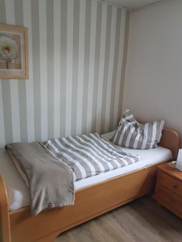 a bed in a room with a striped wall at Ferienhaus Leuchtturm in Geestland