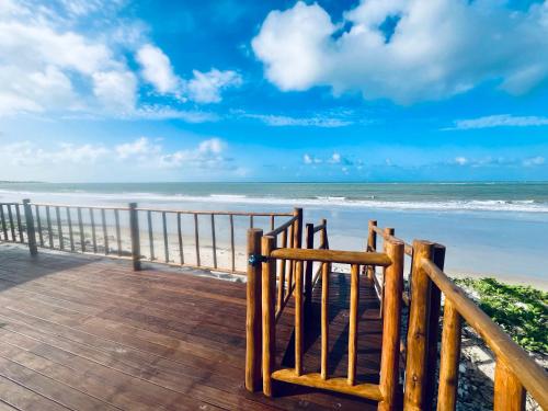 a view of the beach from a wooden boardwalk at Muriú RN - Savage Beach House in Ceará-Mirim