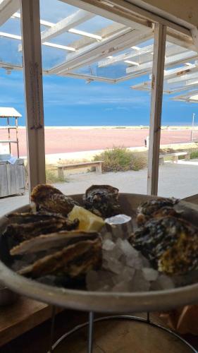 une assiette de nourriture sur une table près d'une plage dans l'établissement appartement la méditerrannée port de gruissan, à Gruissan