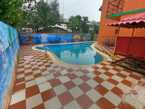 a swimming pool with a checkered floor at Hill Forest Resort in Lonavala