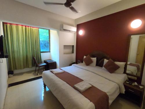 a bedroom with a large bed and a window at Hill Forest Resort in Lonavala