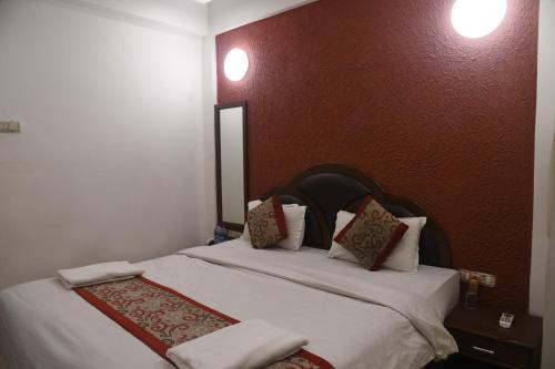 a bedroom with a bed with white sheets and pillows at Hill Forest Resort in Lonavala
