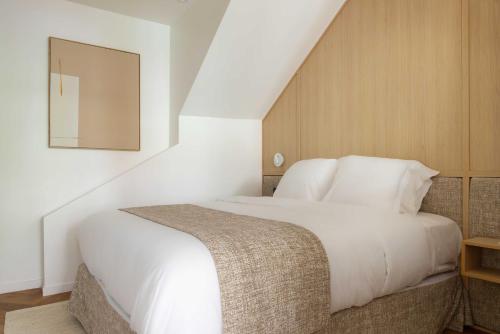 une chambre avec un lit blanc et un miroir dans l'établissement Luxury residence - Port Royal - Rive Gauche, à Paris