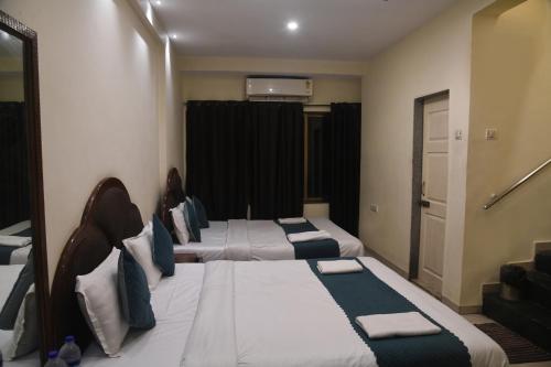 a room with two beds in a room with a window at Hill Forest Resort in Lonavala