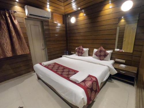 a bedroom with two beds in a room with wooden walls at Hill Forest Resort in Lonavala