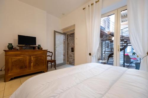 une chambre avec un lit et une télévision sur une commode dans l'établissement Maison des Arts, à Cluny