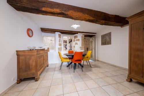 une salle à manger avec une table et des chaises jaunes dans l'établissement Maison des Arts, à Cluny