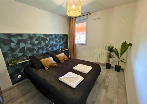 une chambre avec un grand lit avec deux oreillers dessus dans l'établissement Le Jungle - Parking et wifi gratuit - Balcon - Alexa, à Saint-Alban