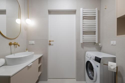 a bathroom with a washing machine and a sink at Apartamenty Cicha - bezpłatny parking in Krynica Zdrój