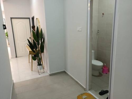 a bathroom with a toilet and a glass shower door at Ruls Homestay Kuala Nerus in Kampong Banggol Setol