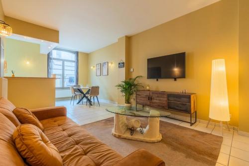 Una sala de estar con un sofá y un televisor de pantalla plana. en One bedroom apartment close to all amenities, en Roubaix