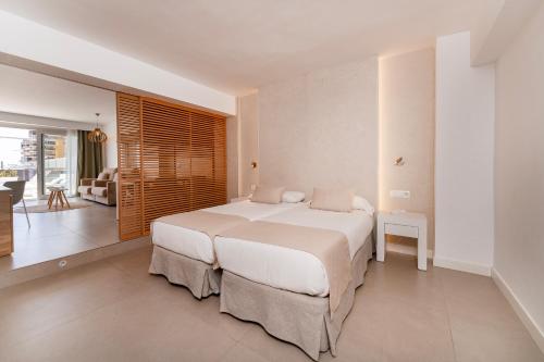 a bedroom with a large bed and a living room at Bordoy Cosmopolitan in Playa de Palma