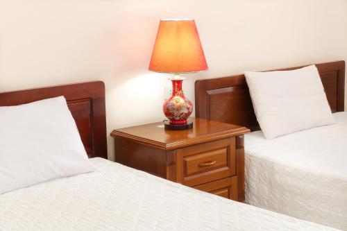 a bedroom with two beds and a lamp on a night stand at Khách sạn Nậm Rốm in Diện Biên Phủ