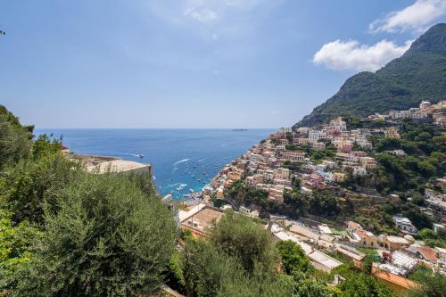 a town on a hill next to the ocean at Casa Vittorina - De Vivo Realty Positano in Positano
