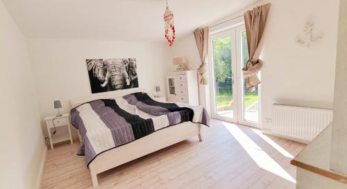 ein Schlafzimmer mit einem Bett und einem großen Fenster in der Unterkunft Das Talhaus in Süsel