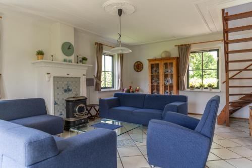 a living room with blue couches and a fireplace at Buitenplaats 86 in Callantsoog