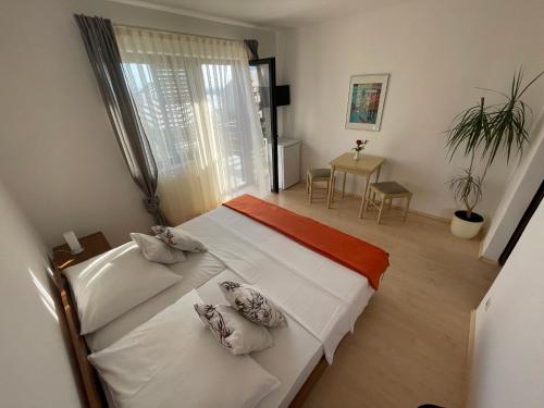 a bedroom with two beds and a table at Sobe-Sandra in Dramalj