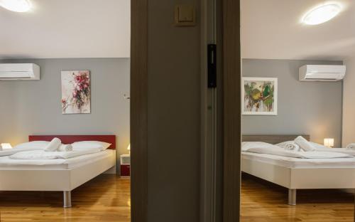 a bedroom with two beds and a mirror at Villa Matko - family destination in Zmijavci