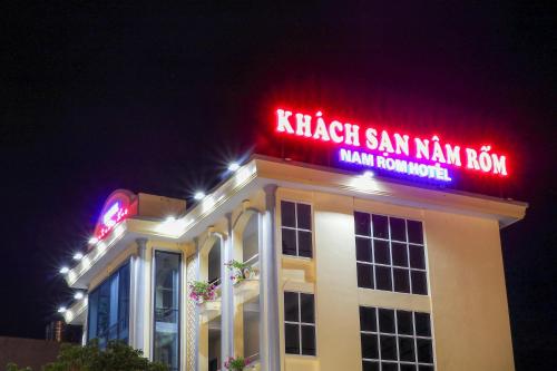 a building with a neon sign on top of it at Khách sạn Nậm Rốm in Diện Biên Phủ
