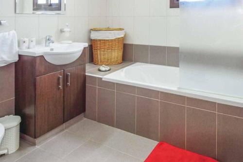 un bagno con vasca e lavandino di Villa Melody Latchi a Neo Chorio