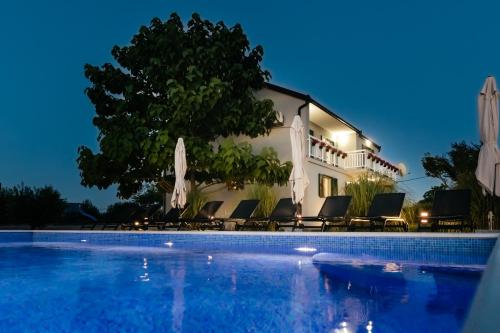 a villa with a swimming pool at night at Villa Matko - family destination in Zmijavci