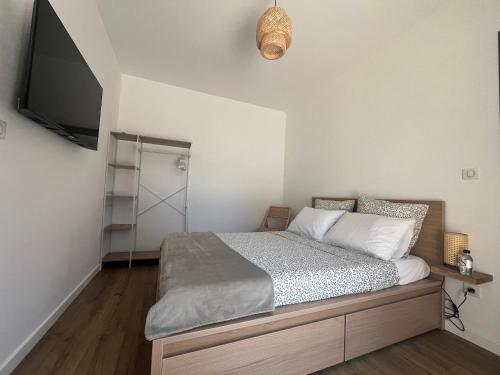 a bedroom with a bed and a flat screen tv at A Felicità in Sainte-Lucie de Porto-Vecchio