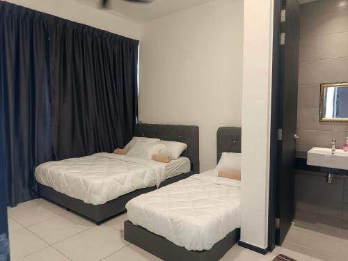 two beds in a room with a sink at Apartment in Georgetown 3BR-10pax in Jelutong