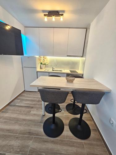 a kitchen with a large wooden table and two stools at Rita Apartments in Makarska