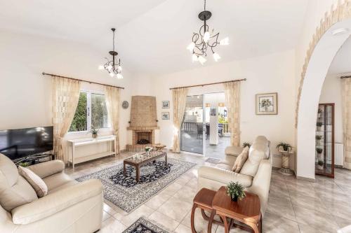 a living room with white furniture and a fireplace at Cliffside Villa in Tala