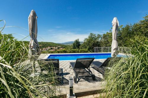 a chair sitting on a patio next to a swimming pool at Villa Matko - family destination in Zmijavci
