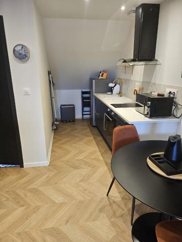- une petite cuisine avec une table et un comptoir dans l'établissement GÎTE Le Parisien Appartement privé en Duplex avec accès jacuzzi à 10min des plages, à Lanhouarneau