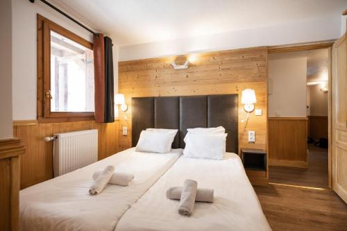a bedroom with a large white bed with two pillows at Résidence Les Balcons de Val Chavière in Val Thorens