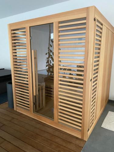 a wooden closet with wooden shutter doors in a room at En vacances Simone ! in Plurien