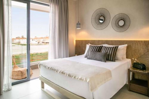 ein Schlafzimmer mit einem großen Bett und einem großen Fenster in der Unterkunft Lora Pearl Luxury Villa in Protaras