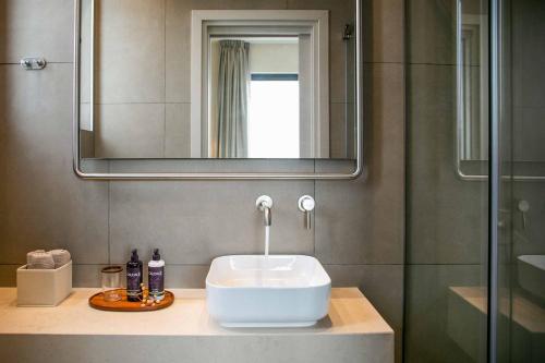 ein Badezimmer mit Waschbecken und Spiegel in der Unterkunft Lora Pearl Luxury Villa in Protaras