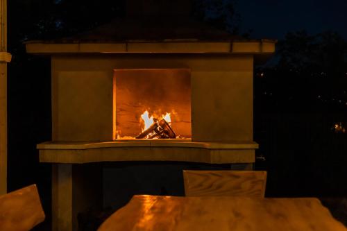 a fire in a stone fireplace at night at Villa Matko - family destination in Zmijavci