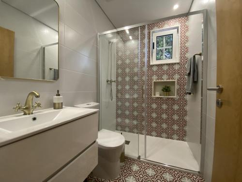 a bathroom with a shower and a toilet and a sink at Quinta de Souto Velho in Terras de Bouro