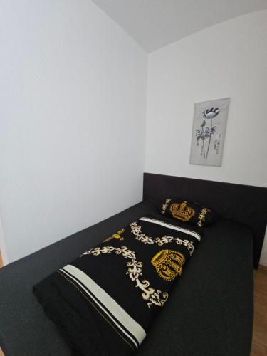 a bed with a black and gold blanket on it at Ferienwohnung in Nordhausen