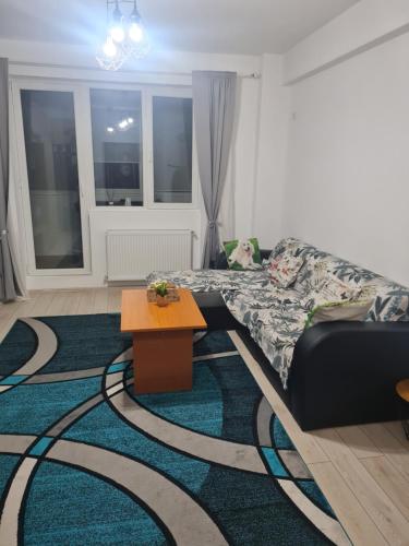 a living room with a bed and a table on a rug at Luxury 1 Bedroom Apartment in Roşu