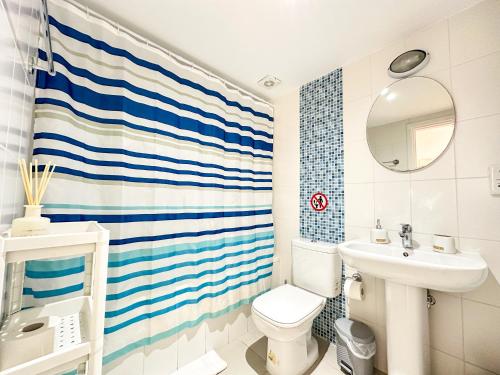 a bathroom with a blue and white striped shower curtain at Sherpa Apartments in Ayia Napa