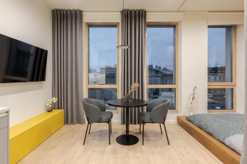 1 dormitorio con mesa, sillas y 1 cama en FORUM apartments, en Leópolis