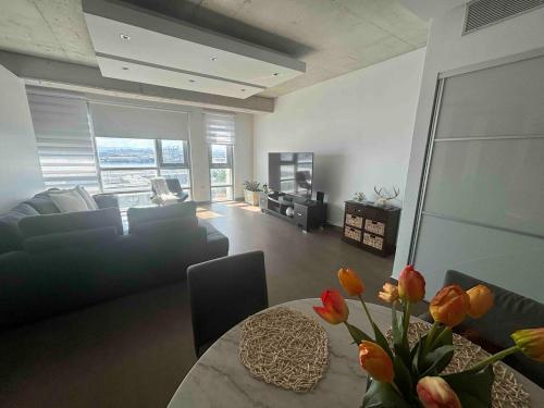 Una sala de estar con un sofá y una mesa con flores. en Atlantis Loft Studio By Stay Here Pr, en San Juan