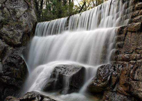 a waterfall flows over a stone wall at Villa Matko - family destination in Zmijavci