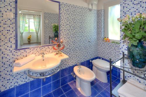 baño de azulejos azules con lavabo y aseo en Villaggio Turistico Internazionale, en Porto Recanati