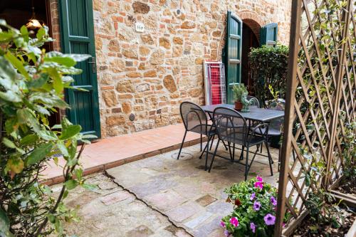a patio with a table and chairs in front of a building at Borgo Il Poggio Agriturismo in Montaione