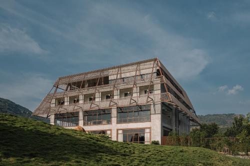 a building on top of a grassy hill at ORO The Estates, Nandi Hills in Nandigunda