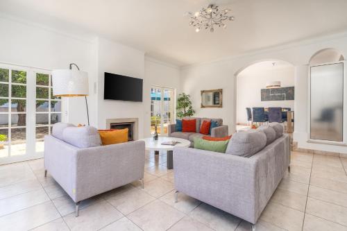 a living room with two couches and a tv at Host Wise - Spacious Family House with Garden in Lagos